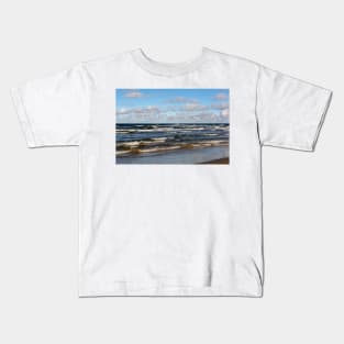 White cumulus clouds in sky over wavy Baltic sea Kids T-Shirt